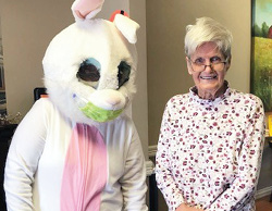 white easter bunny posing with female resident with white hair and wearing a floral blouse