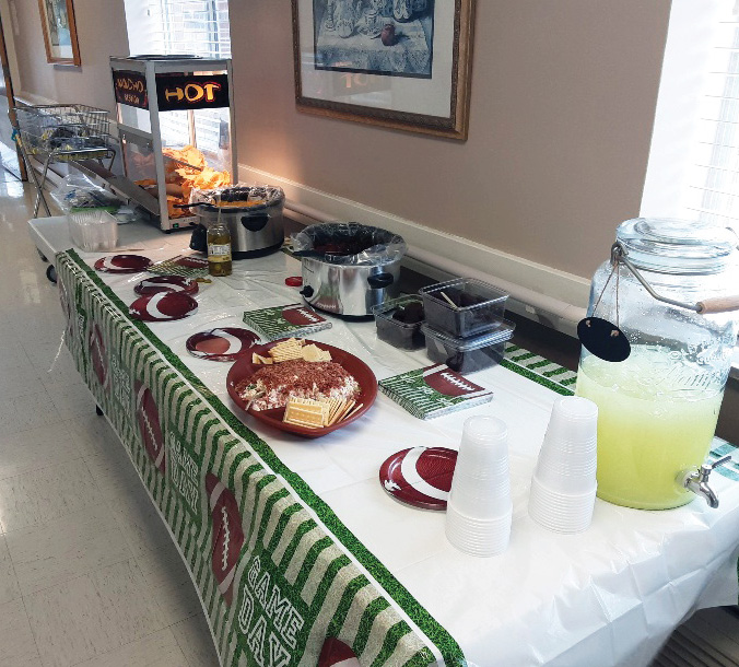 table with potluck style foods and decorated for Superbowl