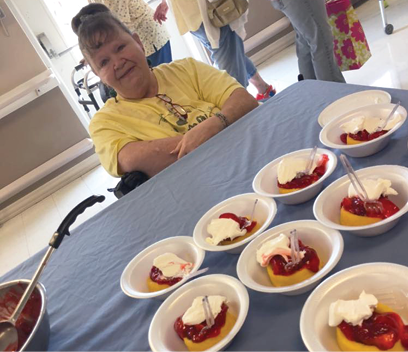 bowls of strawberry shortcake on table in front of a resident of Irvine Nursing and Rehab