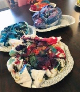 three t shirt being tie dyed on a table