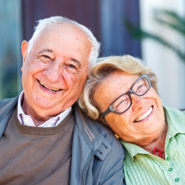 senior couple sitting together outside, smiling, happy, positive